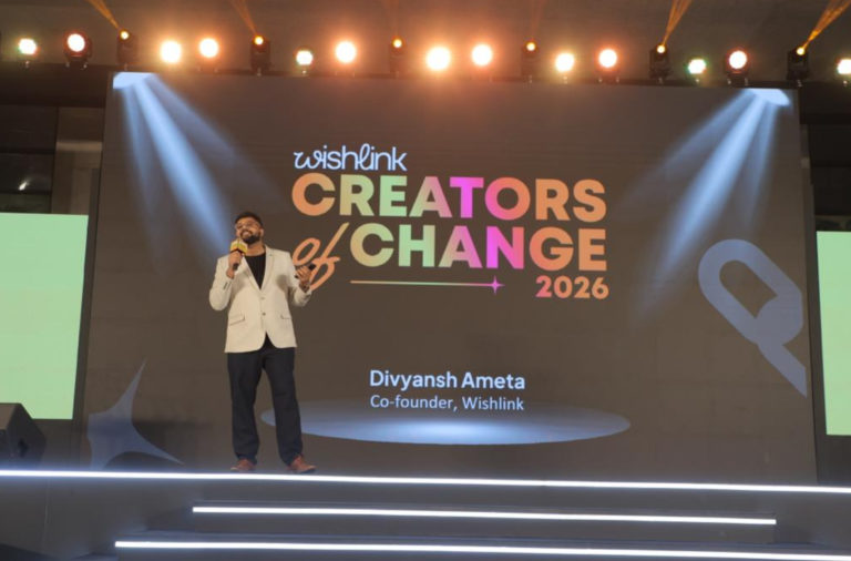 Speaker on a brightly lit stage delivering a talk at Creators of Change 2026 (Wishlink), with a colorful backdrop reading ‘Creators of Change 2026’.