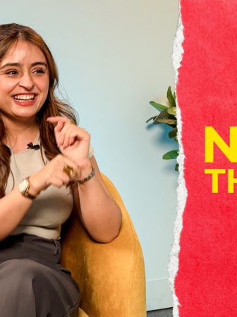 Woman smiling and gesturing while sitting in a mustard chair during an interview; logo visible in the top-left and a red panel with title text on the right.