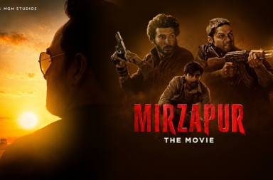 Promotional poster for Mirzapur: The Movie featuring three armed men against a fiery sunset backdrop and a silhouetted foreground figure.